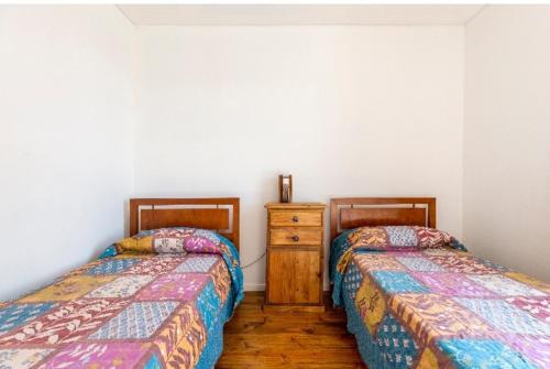 門多薩的住宿－Mendoza San Isidro Cabaña，两张睡床彼此相邻,位于一个房间里