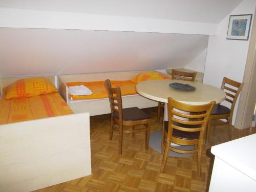 a room with a table and chairs and a bed at Apartmaji Kranjska Gora in Kranjska Gora