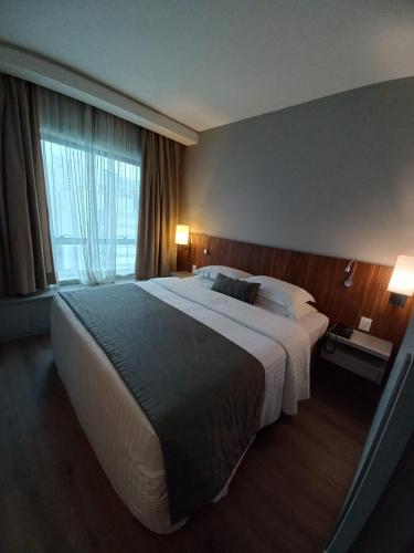 a hotel room with a large bed and a window at Estanplaza Berrini in Sao Paulo