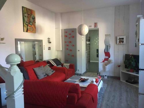 - un salon avec un canapé rouge et une table dans l'établissement Maison de charme au calme à 10mn du centre ville, à La Rochelle