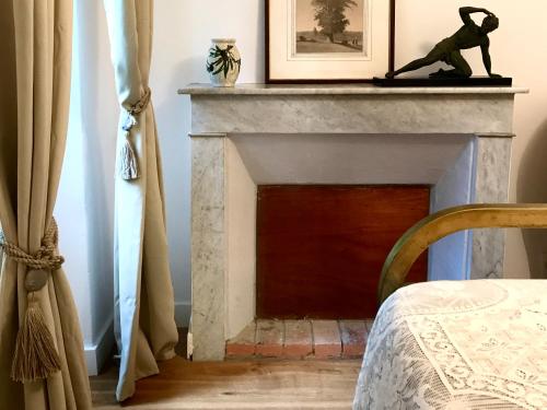 a fireplace with a statue of a monkey on top of it at Housica & Co. in Ucciani