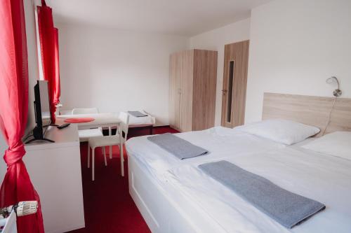 Schlafzimmer mit einem Bett und einem Schreibtisch mit einem TV in der Unterkunft Penzion Quattro in Ústí nad Orlicí