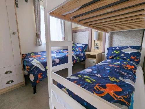 a bunk bed room with two beds and a bunk bed at Flamingo Lodge - Mallard Lake in South Cerney