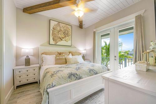 a white bedroom with a bed and a window at Beach Views in Bailey Hall