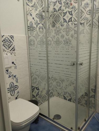 a bathroom with a toilet and a glass shower at Hotel La Giara in Zambrone