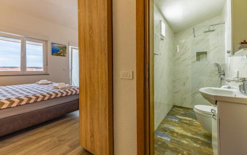 a bathroom with a bed and a toilet and a sink at Villa Asta Medulin in Medulin