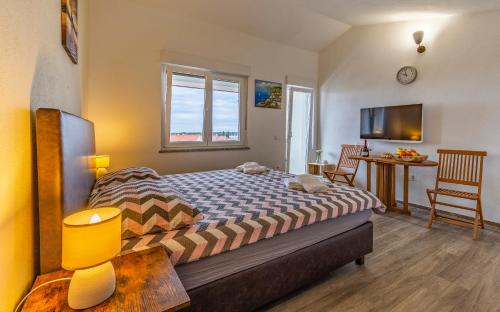 a bedroom with a bed and a table with chairs at Villa Asta Medulin in Medulin