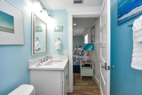 baño con lavabo blanco y pared azul en Bimini Breeze, en Siesta Key