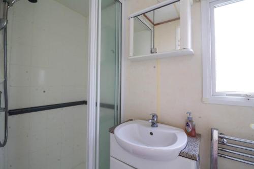 La salle de bains est pourvue d'un lavabo et d'une douche. dans l'établissement 8 Berth Caravan For Hire At California Cliffs Holiday Park In Norfolk Ref 50046l, à Great Yarmouth