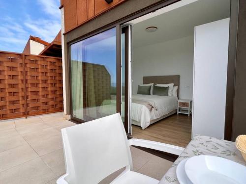 Un dormitorio con una cama y un balcón. en Apartamento Puerta de Comillas - Monabri, en Canales