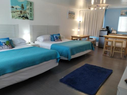 um quarto de hotel com duas camas e uma secretária em Snooze em Fort Lauderdale