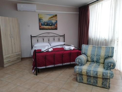 ein Schlafzimmer mit einem Bett und einem Stuhl in der Unterkunft Casa ENGY in Terrasini