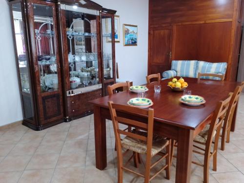 ein Esszimmer mit einem Holztisch und Stühlen in der Unterkunft Casa ENGY in Terrasini
