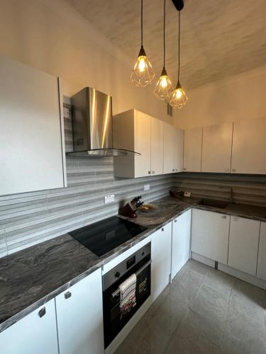 cocina con armarios blancos y encimera en Southsea 2 bedroom 10 mins from Beach en Portsmouth