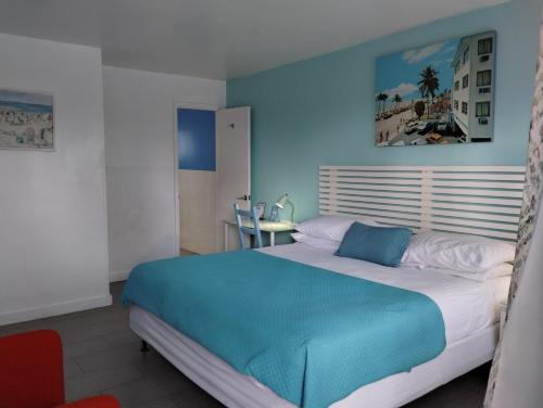 a bedroom with a large bed with a blue wall at Snooze in Fort Lauderdale