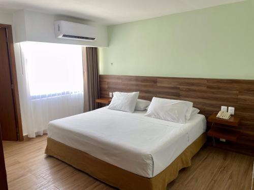 a bedroom with a large white bed and a window at Hotel del Paseo Campeche in Campeche