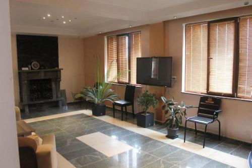a living room with a flat screen tv and plants at Sea in Shekvetili