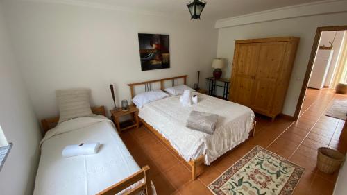 sypialnia z dwoma łóżkami i drzwiami w obiekcie Quinta Amaro AL w mieście Angra do Heroísmo