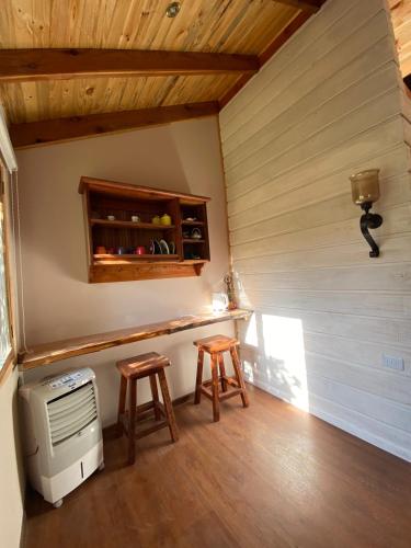 Habitación pequeña con fogones y 2 taburetes en Loft Cabaña El Recuerdo en Maipo