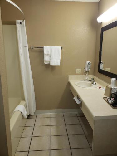 a bathroom with a shower and a sink and a tub at Super 8 by Wyndham Clinton in Clinton