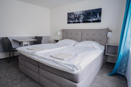 a bedroom with a large bed with white sheets at Penzion Quattro in Ústí nad Orlicí