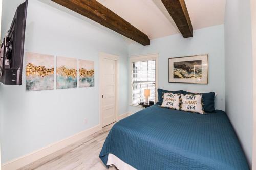 Schlafzimmer mit blauem Bett und weißen Wänden in der Unterkunft Sugar Sand Cottage in Siesta Key
