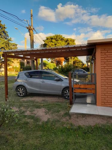 um carro estacionado sob uma garagem ao lado de um edifício em Apartamento en Colonia em Colónia do Sacramento