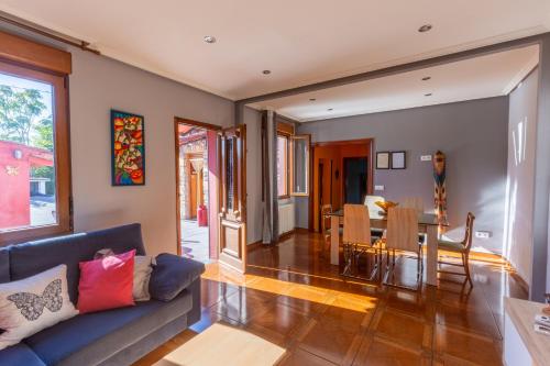a living room with a couch and a table at Casa Rural La Sosiega con jardín privado in Bernueces