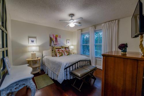 a bedroom with a bed with a ceiling fan and a window at Bama Bungalow in Tuscaloosa