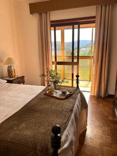 a bedroom with a bed and a large window at Casa Vicente in Lamego