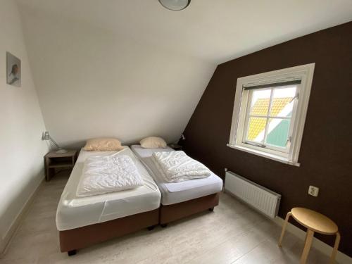 HippolytushoefにあるComfortable villa with garden, near the Wadden Seaの小さなベッドルーム(ベッド1台、窓付)