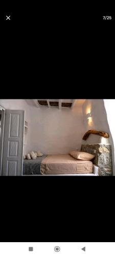 1 dormitorio pequeño con 2 camas y puerta en Mikro Kastro, en Amorgós