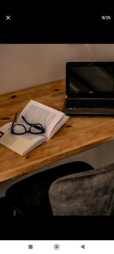 een bureau met een laptop, een boek en glazen bij Mikro Kastro in Amorgós