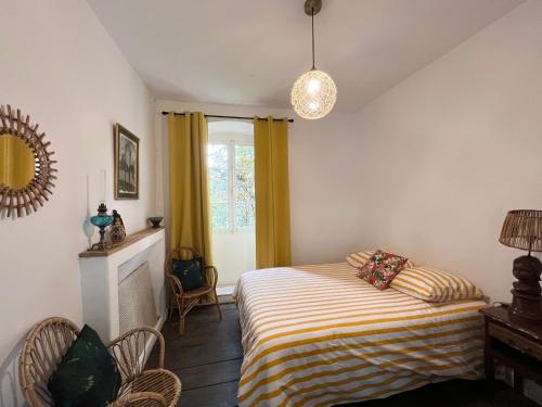 a bedroom with a bed with a striped blanket and a window at Housica & Co 2 in Ucciani