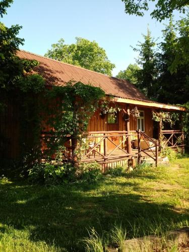 duży drewniany dom z trawnikiem przed nim w obiekcie Siedlisko Urszulanka w mieście Policzna