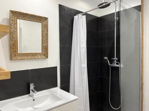 een badkamer met een douche, een wastafel en een spiegel bij Housica & Co 2 in Ucciani