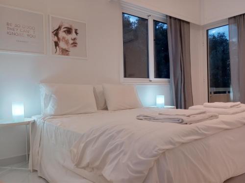 a white bed with white sheets and pillows on it at Zelea Deluxe Apartment (BREAKBOOKING CY) in Limassol