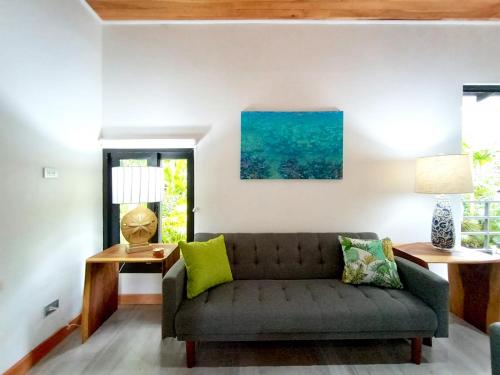 a living room with a couch and a window at Dragonfly Beach Retreat Beachfront Casitas-Adult Only in Punta Uva