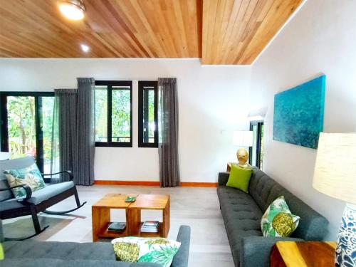uma sala de estar com um sofá e uma mesa em Dragonfly Beach Retreat Beachfront Casitas-Adult Only em Punta Uva