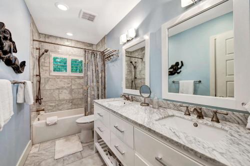 bagno con lavandino, servizi igienici e specchio di Blue Palm a Bailey Hall