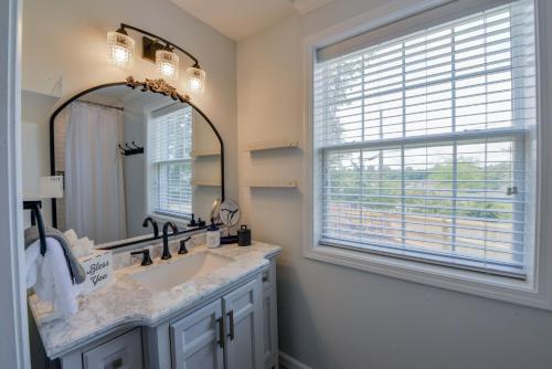 a bathroom with a sink and a mirror and a window at Bama Cottage in Tuscaloosa