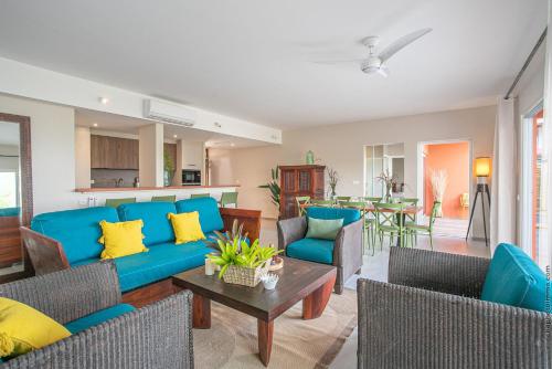 a living room with a blue couch and chairs at Villa Maorie 5 chambres avec piscine privée in Le François