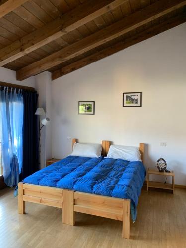 a bedroom with a large bed with a blue comforter at La Via del Sale in Sanfront