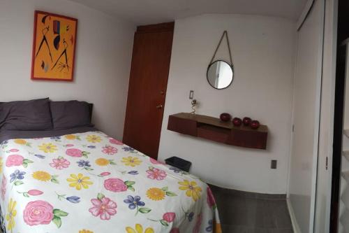 a bedroom with a bed with a floral bedspread at Casa 2 recámaras in Mexico City