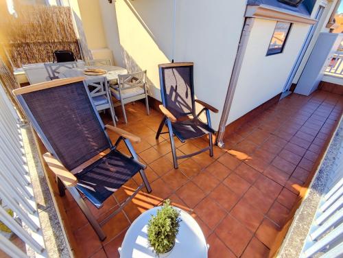 Habitación con vistas a un balcón con sillas y mesa. en Ático Playa Sada en Sada