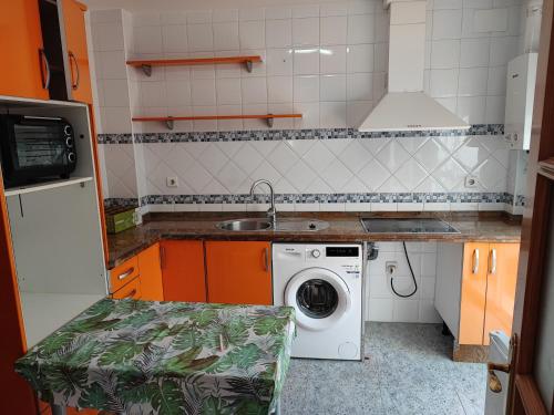 a kitchen with a sink and a washing machine at Centro Isla Cristina in Isla Cristina
