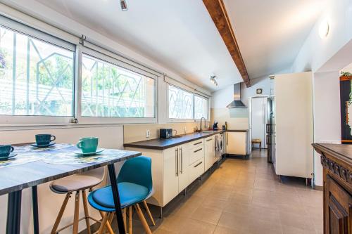 une cuisine avec une table, des chaises et des fenêtres dans l'établissement VILLA PROVENCE-SPA&BBQ CENTRE AU CALME- JARDIN - TERRASSES, à La Valette-du-Var