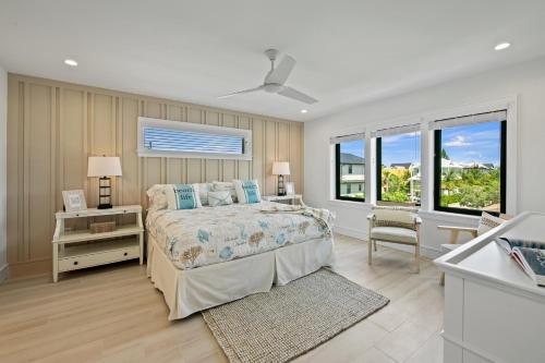 a bedroom with a bed and a desk and windows at Vitamin Sea in Sarasota