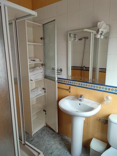 a bathroom with a sink and a toilet and a mirror at Centro Isla Cristina in Isla Cristina