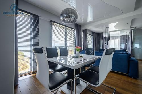 a dining room with a table and chairs at Prezydencki Apartamenty z widokiem na morze in Jarosławiec
